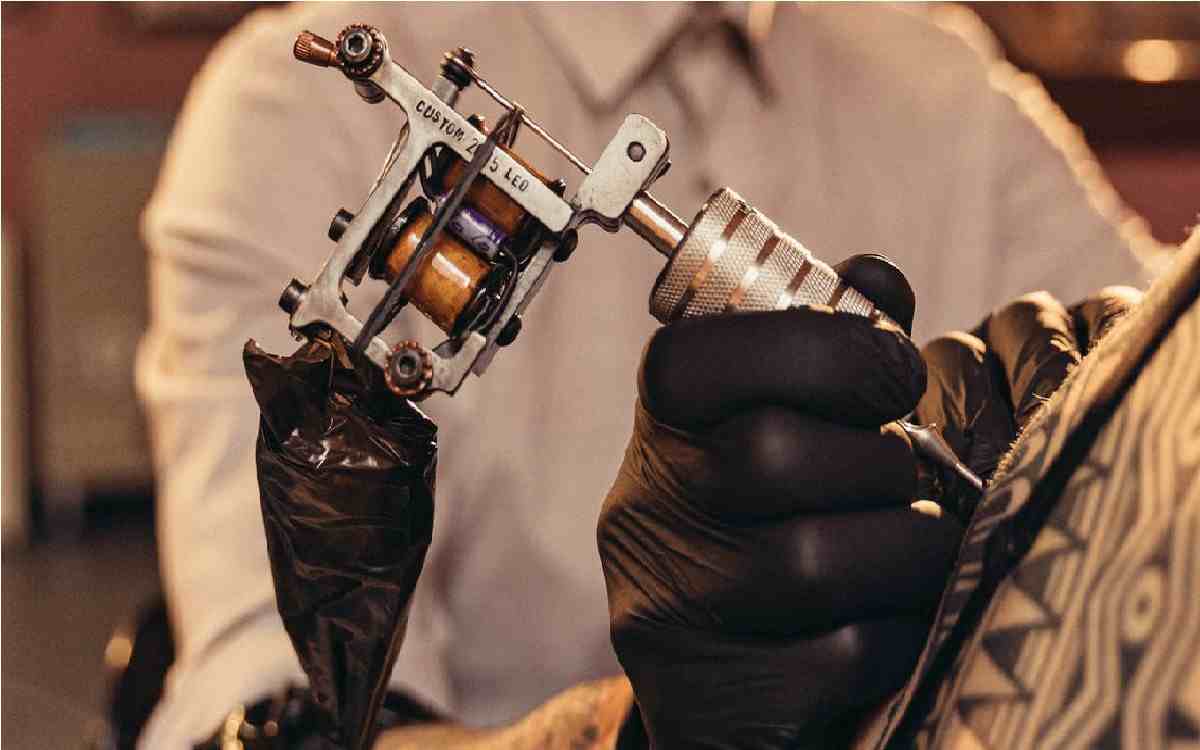 maquina de tatuar siendo manipulada por tatuador